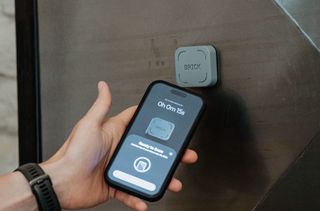 User tapping their on the Brick to Unbrick. Phone screen reads 'Ready to Scan'