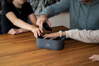A family putting their phones in the Mindsight Lock Box at the table