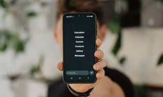 The balance phone homescreen held by a man on blurry background